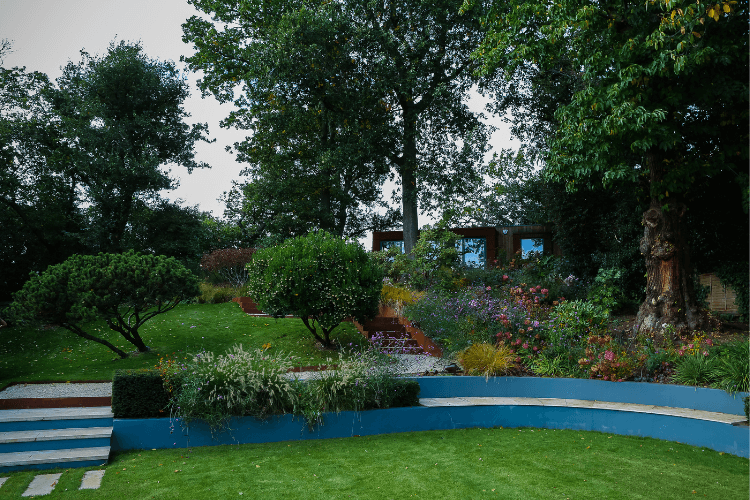 pool house discreetly hidden by formal planting and path up to