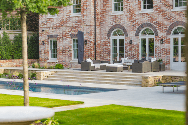 Swimming pool terrace designed as a natural extension of the house, with seating, steps and integrated garden planting