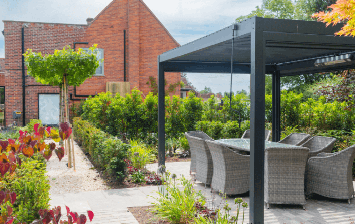 landscaped garden with pergola with dining area